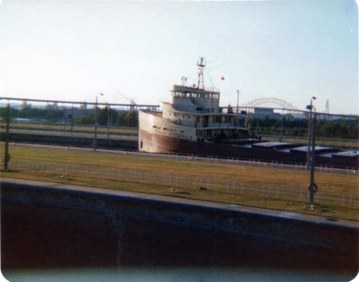 Never before published photo of the Edmund Fitzgerald, taken only months before it was lost with all hands in Lake Superior. Remember, you saw if first on Flickr! My father-in-law took this shot. He told my wife that he wasn't taking a picture of the Big Fitz; he just wanted a photo of the locks, and this happened to be in the photo. Unfortunately, the negative is long gone and this photo was printed on some sort of rough-coated matte paper so that it could be mailed as a postcard. My father-in-law didn't realize until months after the sinking that he had a picture of this vessel. The photo was taken in August 1975; the Edmund Fitgerald sank in November of that year. It was, ironically, the sinking that made this ship famous. After it was built it was the largest ship on the Great Lakes, but other than that, it was just another anonymous working vessel plying the waters between Wisconsin and Michigan.